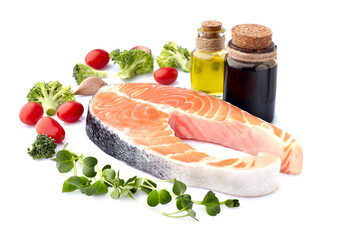 Salmon fish on the white background with fresh  vegetables, olive oil and balsamic vinegar.  Salmon steak isolated.