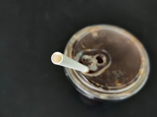 Selective focus of paper drinking straw in a ice coffee glass. Paper product is good for environment more than plastic. Object, drink, and environment concept.