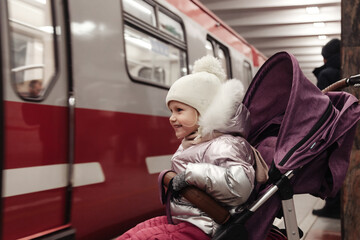 Little girl in stroller on subway underground station in public metropolitan transportation
