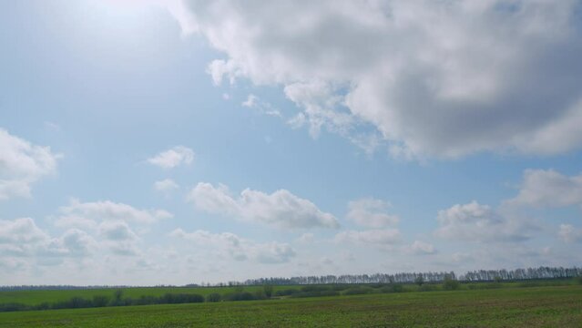 Flying clouds over the forests and grasslands. Farm meadows in spring.