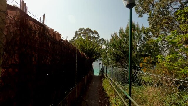 Narrow path to secluded beach in the Aldan estuary, Galicia, Spain, dolly in