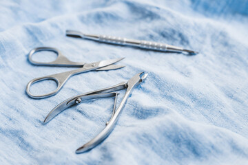 A set of tools for professional manicure, nail care and to create beautiful designs on a blue background. Top view.