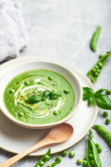 Green peas soup. Healthy vegan green peas soup served in bowl on rustic table.