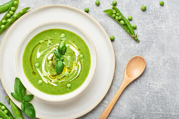 Green peas soup. Healthy vegan green peas soup served in bowl on rustic table.