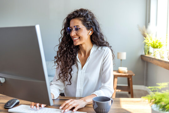 Shot of a young businesswoman working on a computer in an office. Portrait of an successful young creative businesswoman using PC at her workplace in the modern office
