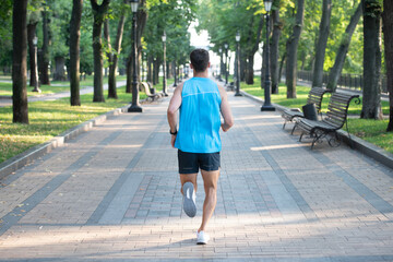 athletic man runner running in sportswear outdoor. back view