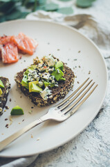 Healthy breakfast with salmon and toasts with rye bread, avocado and blue cheese