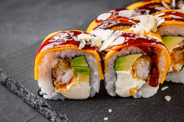 delicious sushi rolls on a black stone background