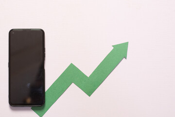phone and arrow showing rise on a desk