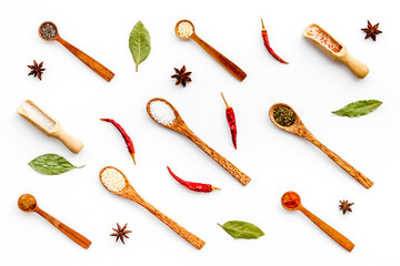 Layout of spices and herbs in wooden spoons, top view