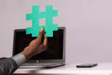 african businessman holding a hash tag symbol
