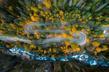 Top view of mountain road in forest with blue river