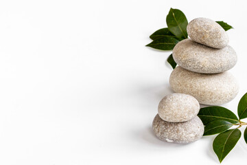 Fototapeta na wymiar Spa stones for massage with leaves for beauty therapy