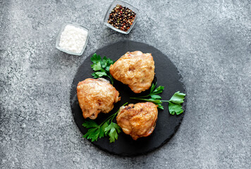 grilled chicken thighs on stone background