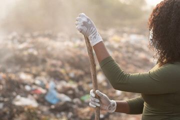 african woman wearing gloves at a refuse site for clean up