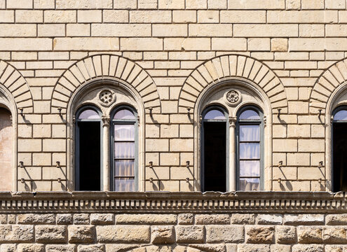 Detail of the façade of Medici Riccardi palace designed by Renaissance architect Michelozzo with two mullioned windows, in Florence city center, Tuscany region, Italy