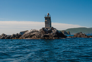 Old lighthouse. Sea travel by boat.
