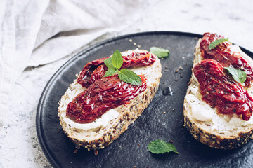 Bread slices with cream cheese and sun dried tomatoes