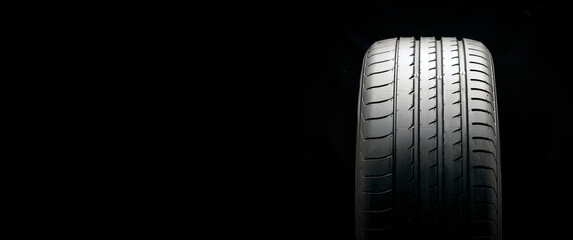 new summer tire on a black background, copyspace is a place for advertising © Vladimir Razgulyaev