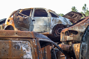 A lot of rusty burnt cars in Irpen, after being shot by the Russian military. Russia's war against Ukraine. Cemetery of destroyed cars of civilians who tried to evacuate from the war zone.