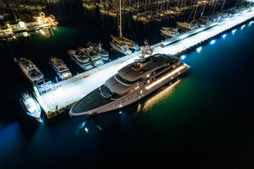 Luxury motor super yacht moored to pier at night (aerial drone photo). Marmaris, Turkey
