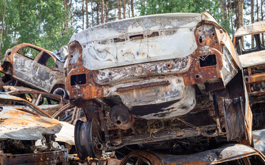 A lot of rusty burnt cars in Irpen, after being shot by the Russian military. Russia's war against Ukraine. Cemetery of destroyed cars of civilians who tried to evacuate from the war zone.