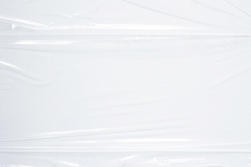 Transparent plastic wrap on white color background. Crumpled wrinkled plastic cellophane. Reflecting light and shadow on creases and folds in plastic surface. Texture overlay effect template