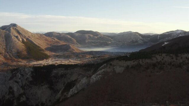 Aerial drone view above mountainous Kotor Bay at sunrise in bright morning