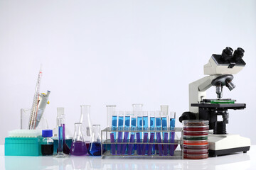 Microscope on the table with chemical tube and glassware in laboratory, Science research technology on the table and white background