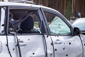 Car riddled with bullets. War of Russia against Ukraine. A car of civilians shot by the Russian military during the evacuation of women and children. Traces of bullets and fragments of shells.