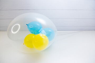 yellow and blue balloons in a transparent balloon