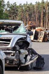 Dump of shot and burned civilian cars by Russian invaders in Ukraine. The remains of cars that were shot and destroyed by shell fragments. War of Russia against Ukraine. Car graveyard.