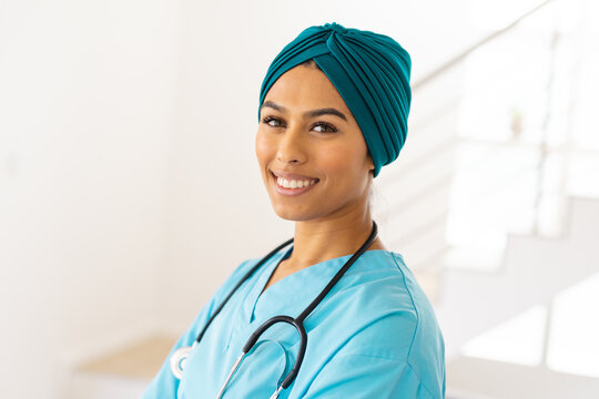 Portrait of smiling biracial young female doctor in hijab at clinic