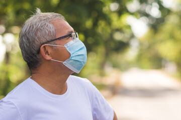 Old Asian man walking exercise outdoor and wearing medical mask