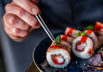 Man hand chef cooking sushi rolls, japanese food