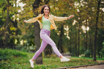 Full length body size view of attractive funky cheerful girl jumping having fun enjoying spending time outdoors