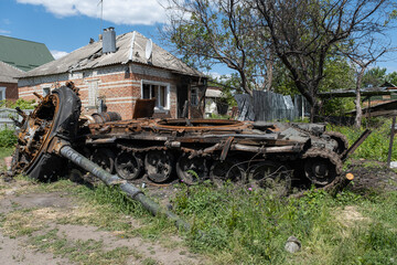 A burnt Russian tank near a residential building. War in Ukraine 2022. Russian missiles in Kharkiv countryside Ukraine. Russian aggression. Russian attack on Ukraine. 