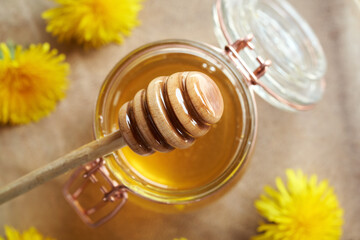 Honey dipper over a jar of dandelion honey