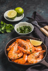 Shrimps grilled, prawns served with lime and sauce on a dark background. Seafood. 