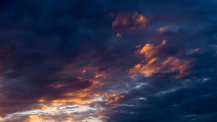 De magnifiques teintes orangées colorent le ciel du crépuscule, sous des nuages de moyenne altitude