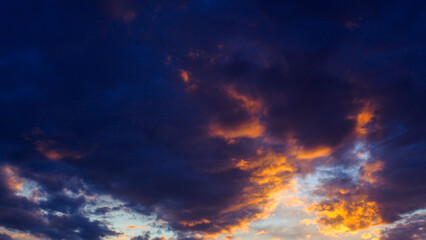 Naklejka na ściany i meble De magnifiques teintes orangées colorent le ciel du crépuscule, sous des nuages de moyenne altitude