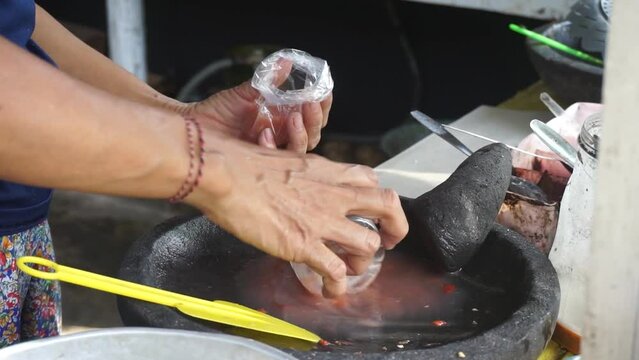 A merchant is mixing rujak spices. Rujak is a typical Indonesian food, consisting of fresh fruits and spicy spices.