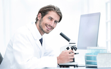 Male Chemist Scientific Reseacher using Microscope in Laboratory