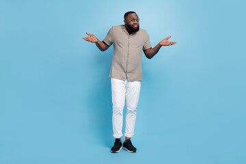 Full body portrait of uncertain clueless person shrug shoulders isolated on blue color background