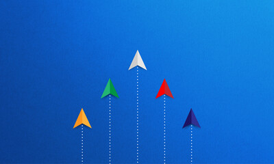 Group of colored paper planes lead by withe one  on blue background. Business competition, different vision creative and innovative solution concept. same goal concept.
