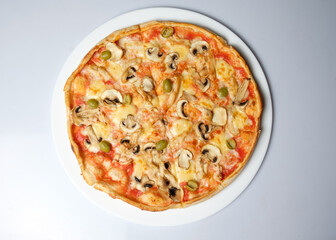Tasty pizza with cooking ingredients and kitchen tools
on white background.
