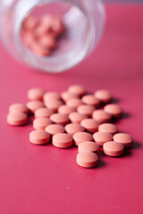 pain killer spilling form a container on a red background 