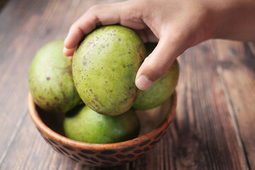Fresh green mango in a bowl on table 