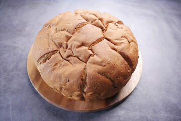  top view of round brown baked bread on chopping board 