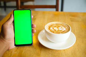 holding a cpu of coffee and using smart phone with green screen 